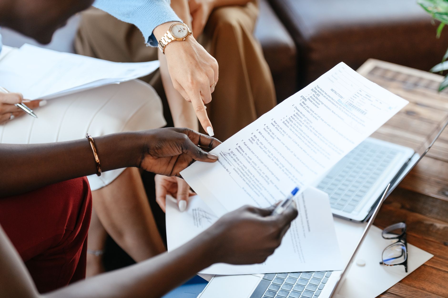 Mãos analisando documentos impressos sobre uma mesa